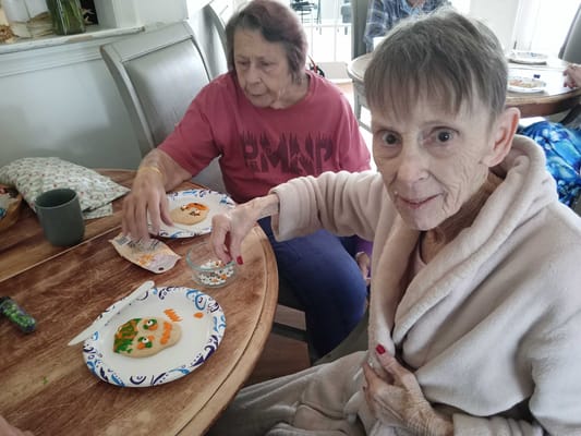 Residents decorating plates with food in a common area