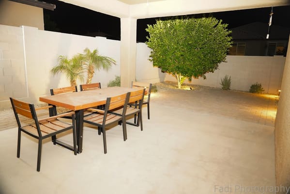Night view of outdoor patio with dining table and plants
