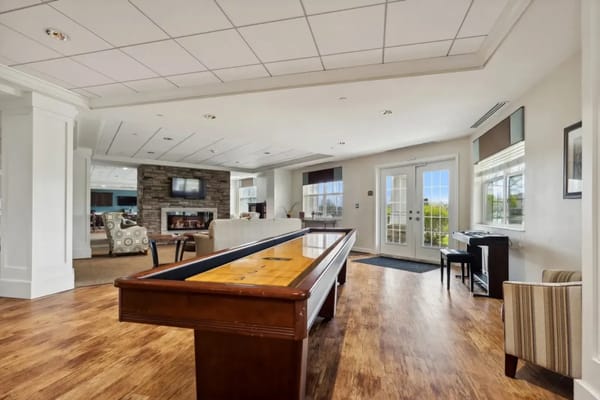 Bright common area with shuffleboard table and comfortable seating