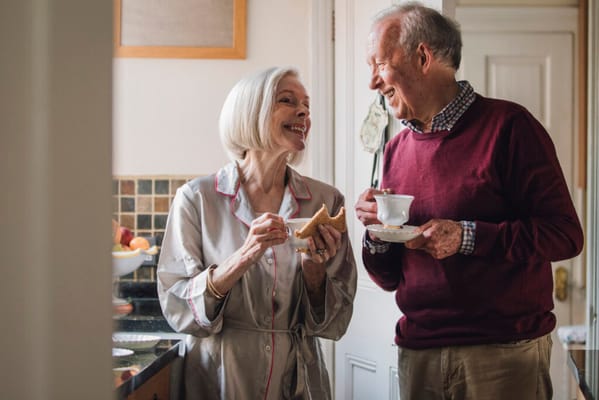Couple enjoying tea and snacks in a cozy kitchen