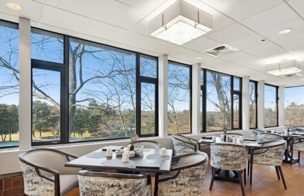 Bright dining area with large windows overlooking outdoor space