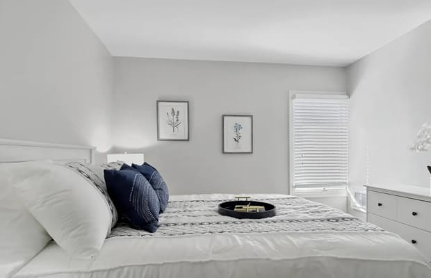 A cozy bedroom with neutral decor and a neatly made bed