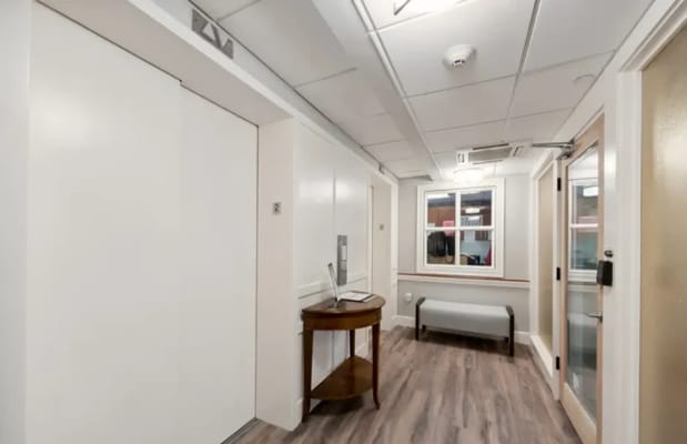Interior hallway with elevator and seating area