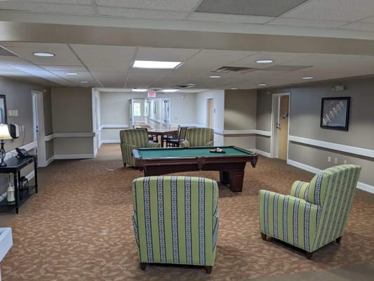 Interior view of a common area with seating and a pool table