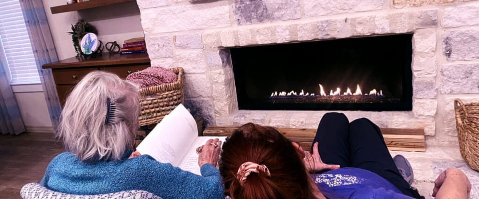 Two residents relaxing by a cozy fire