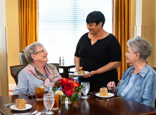 Two women enjoying dessert while being served