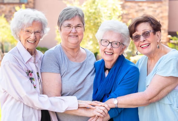 Four smiling women enjoying outdoor time together