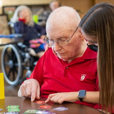 Resident and staff member playing a game together