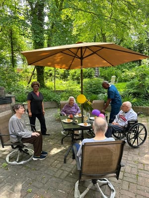 Residents enjoying time outdoors under an umbrella