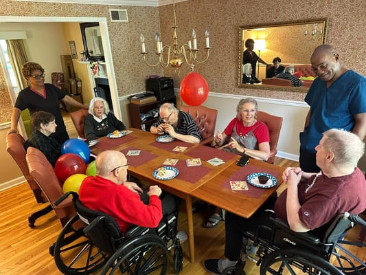 Residents celebrating at a communal table with staff