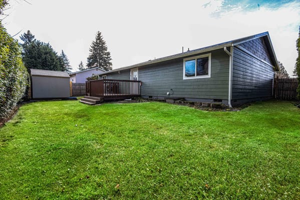 Well-maintained backyard with green lawn and deck
