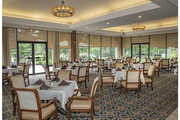 Dining room with tables and chairs set for residents