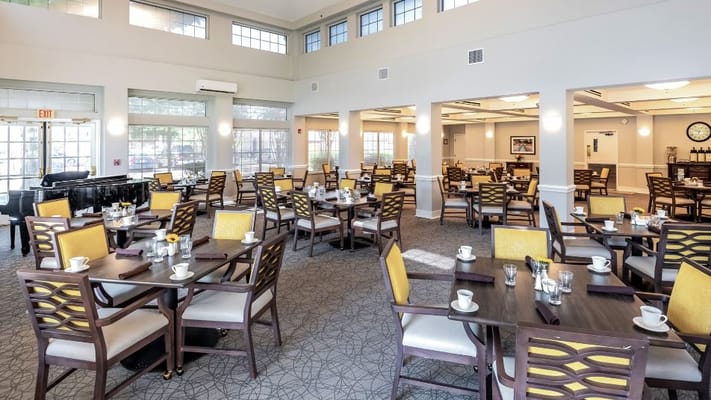 Bright dining room set for a meal with tables and chairs