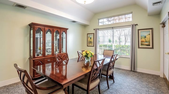 Bright dining room with a large wooden table and floral centerpiece