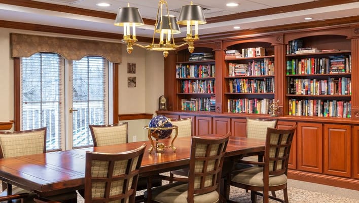 Well-furnished common area with bookshelves and dining table