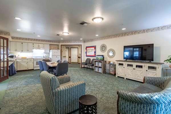 Common area with seating and television in a senior living facility