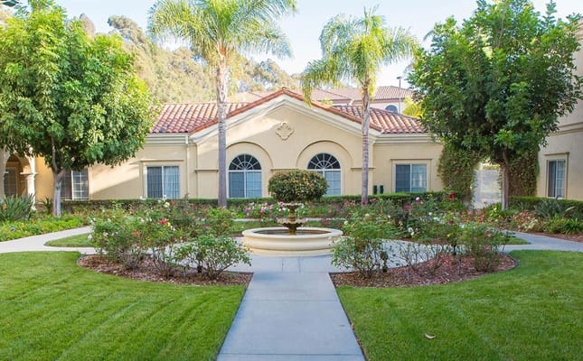 A beautiful garden area with a fountain and landscaping