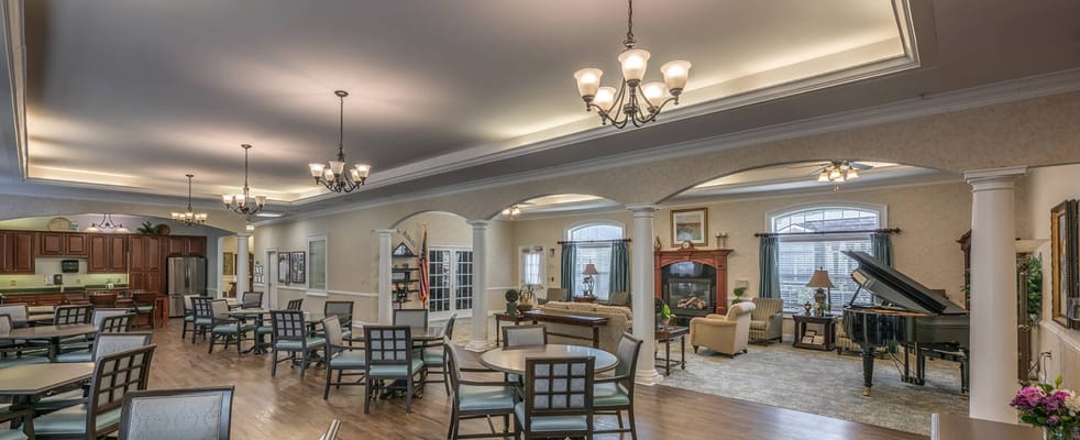 Bright common area with seating, piano, and decor