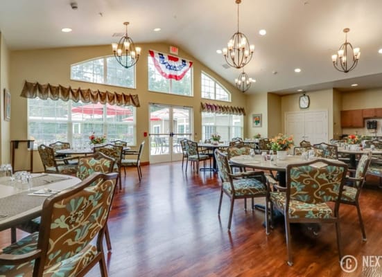 Bright dining area with floral-patterned chairs and large windows