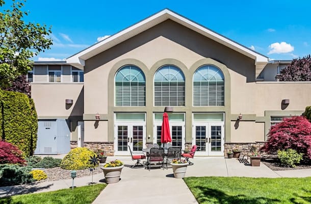 Patio area with seating and a red umbrella outside the Cascades of Chesterley