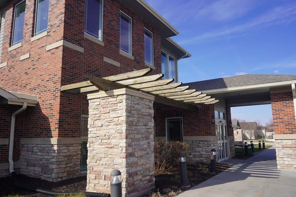 Exterior view of a nursing home entrance with stone archway.