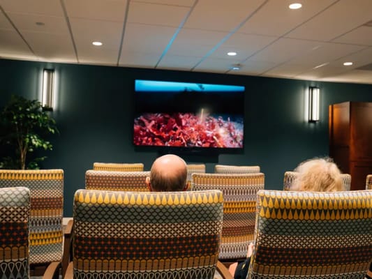 Residents watching a movie in a cozy common area
