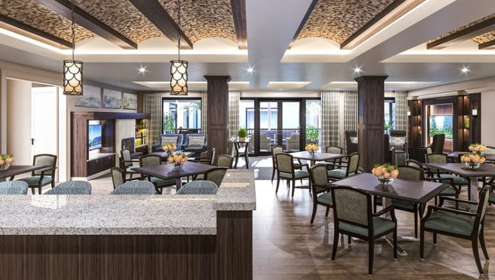 Spacious dining area with tables and greenery at Frontier Senior Living