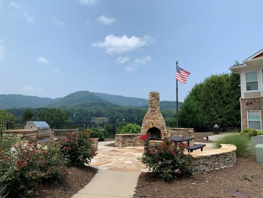 Outdoor gathering area with stone fireplace and American flag