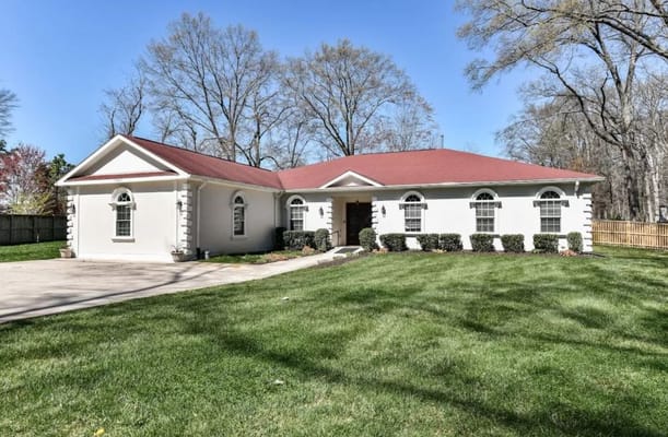 Exterior view of a senior living facility with a green lawn