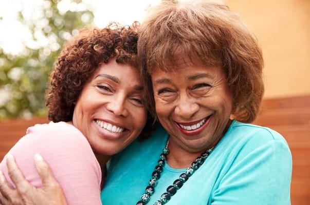 Two women smiling together in a garden setting