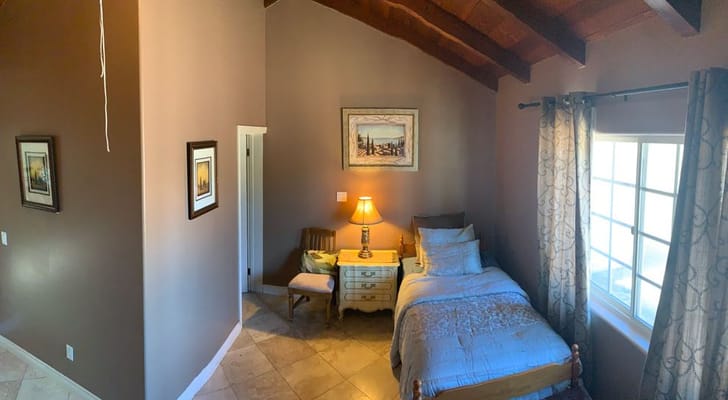 Cozy bedroom with bed, lamp, and artwork