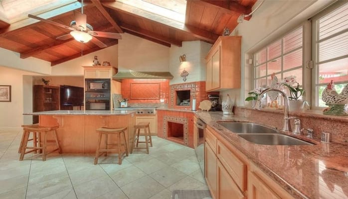 Modern kitchen with wooden ceiling and granite countertops