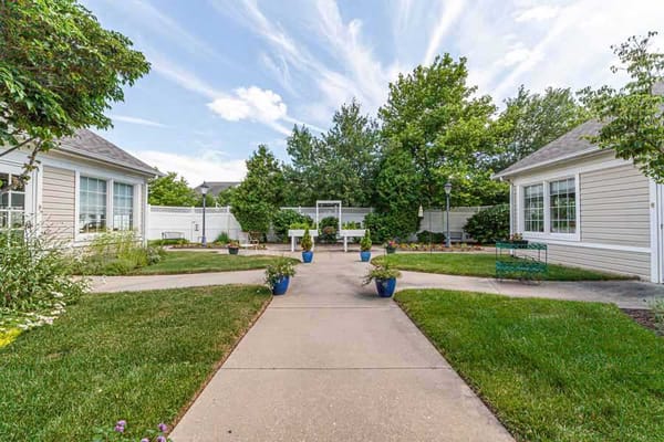 A tranquil garden path with planters at HeartFields Assisted Living.