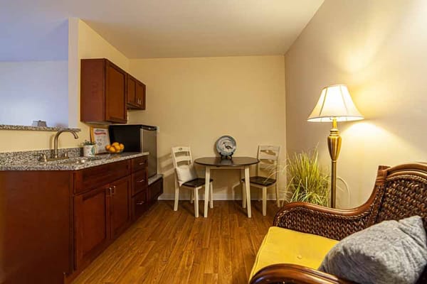 Kitchenette and dining area with table and chairs in a senior living facility