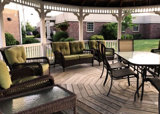 Wicker seating with green cushions in a gazebo