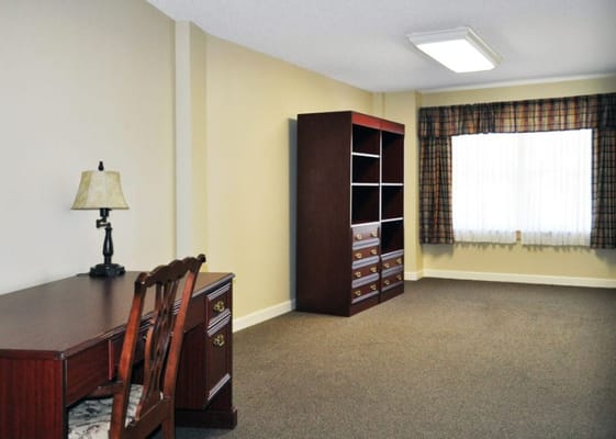 Inside view of a private room with a desk and shelving unit