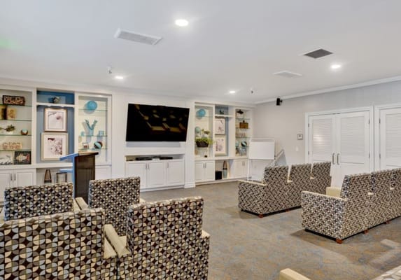 Seating area with patterned chairs and a large TV