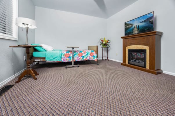 Bright resident room with a bed and fireplace