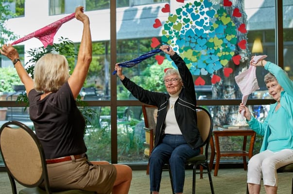 Seniors participating in an exercise class with colorful scarves.