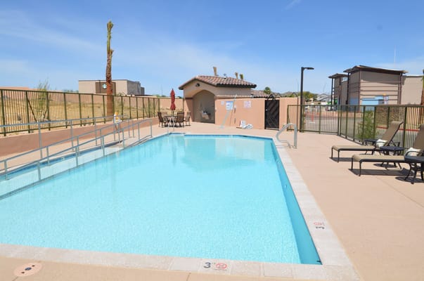 Outdoor pool area with seating and palm tree