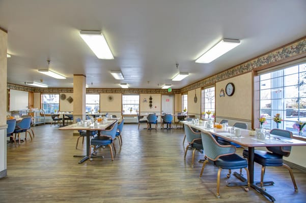 Bright and spacious dining room with tables set for meals
