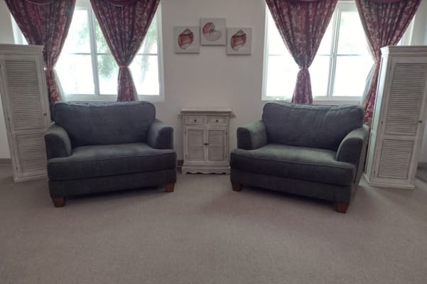 Two green sofas facing each other in a bright living room.