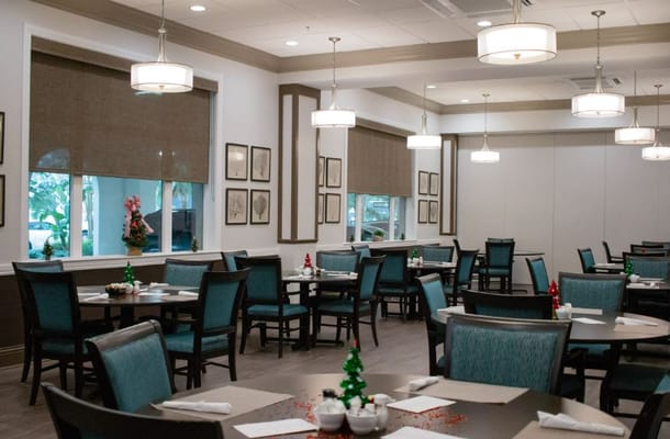 A view of the dining room with tables and chairs decorated for the holidays.