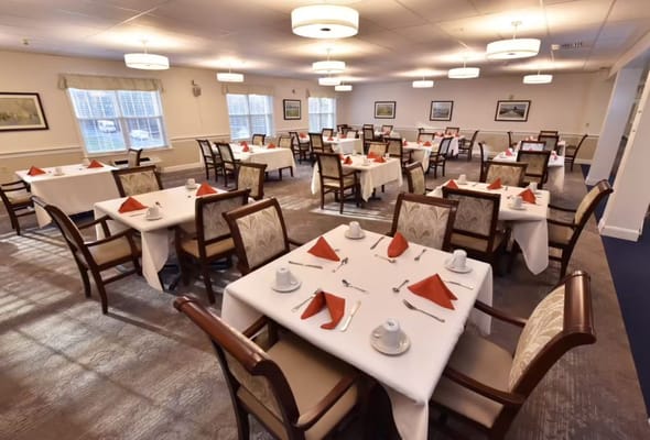 Brightly lit dining room with neatly arranged tables and seats