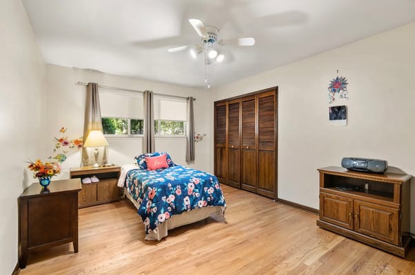 Cozy private bedroom with floral decor and wooden furniture