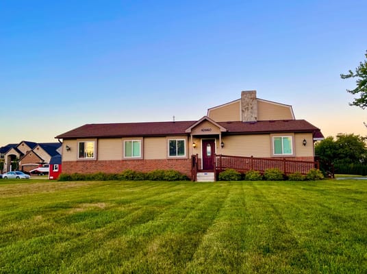 Exterior view of the facility with green lawn and clear sky
