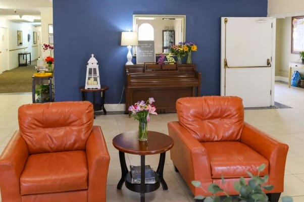 Bright lounge with orange armchairs and a small table