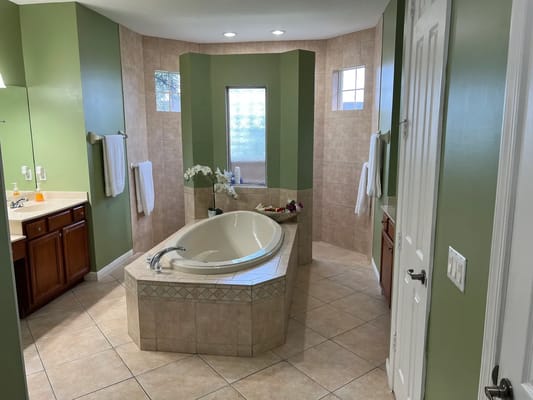 Large bathroom featuring a soaking tub and green walls