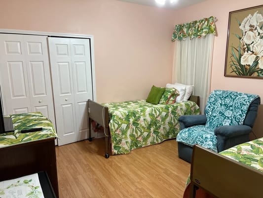 Interior view of a resident room with beds and a recliner