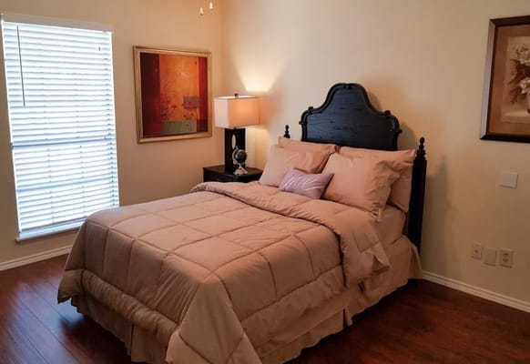 A well-furnished bedroom with a bed and bedside lamp